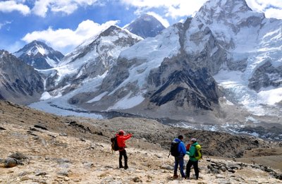  Trekkingtouristen am Aussichtsberg Kala Patthar (5545 m) mit Blick auf die Gipfelpyramide des Mount Everest (Mitte) und den Khumbu-Eisbruch (links). 