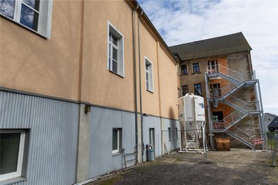 Auf der Rückseite des ehemaligen Gasthofes mit Saalanbau wurde unter anderem eine Fluchttreppe angebaut.