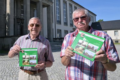 Die Oelsnitzer Hobbychronisten Dr. Günter Hübsch (li.) und Christian Bauer (re.) halten den fünften Band des Oelsnitzer Lexikons als Sonderausgabe „100 Jahren Stadtrecht“ in Händen.