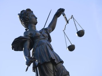            Eine Statue der Justitia steht unter freiem Himmel.