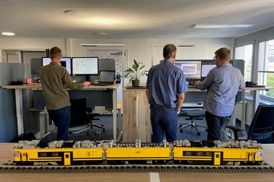 Seit sie hochfahrbare Schreibtische haben, arbeiten viele Mitarbeiter bei Stadler im Stehen. Davor ein Modell eines Tunnelrettungszuges.