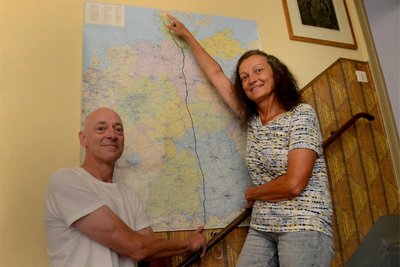 Stefan und Romy Marienthal vor der Deutschlandkarte, auf der sie die Route ihrer Fernwanderung markiert haben.