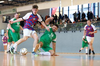 27. Indoor Soccer Cup in Klingenthal: Erst das Neunmeterschießen bringt den Sieger - Hier versucht Benjamin Reitzenstein vom FSV Zwota (rechts in Grün) Linus Machoy von FC Biercelona (am Ball) am Schuss zu hindern.