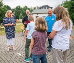 Mathias Hofmann, der Vorstand der Kindervereinigung Chemnitz (Mitte), und Sozialministerin Petra Köpping (links) beim Gespräch mit Schülern, die sich derzeit in der Tabakstanne aufhalten.