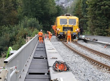 Mit einer sogenannten Gleisstopfmaschine wurde der Schotter unter und neben den Gleisen verdichtet. Links im Bild sind Mitarbeiter des Unternehmens dabei, die Gangstege und Geländer auszurichten und zu befestigen.