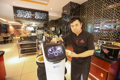 Mirko Yu mit einem „Bellabot“, der die Gerichte im „Asia Palast“ und im „Yummi Sushi“ zu den Tischen der Gäste fährt.