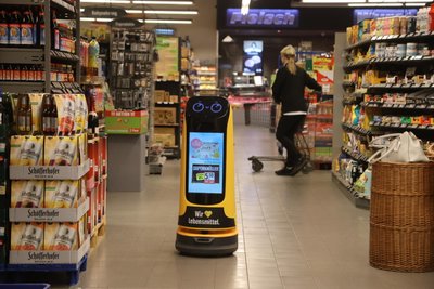 Im Edeka an der Weststraße fährt der Roboter durch die Gänge und bewirbt neue Produkte Sonderangebote.