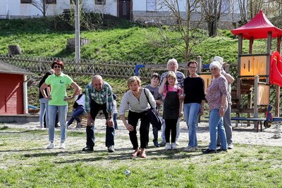 Jung und Alt spielen gemeinsam Boule.