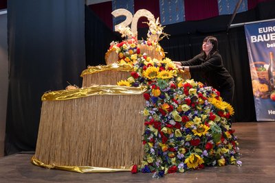 Die Deko ist in diesem Jahr auch aufs Jubiläum abgestimmt. Gestalterin Jana Wild kreierte dazu Bühnenschmuck in Tortenform, reichlich bestückt mit Kunstblumen.