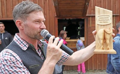 Michael Martin vom Wolfsgrunder Festhof präsentiert den Wanderpokal des Bull-Riding-Wettbewerbs.