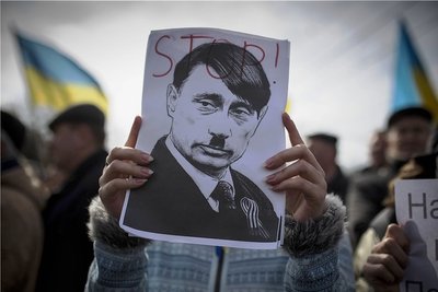 Bereits vor acht Jahren zeigen Demonstranten in Simferopol, der Hauptstadt der Autonomen Republik Krim, ein Plakat, das den russischen Präsidenten Wladimir Putin als den deutschen Diktator Adolf Hitler porträtiert. 