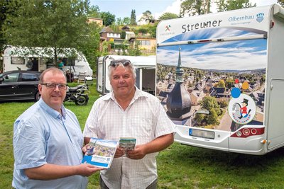 Udo Brückner (l.), Leiter der Touristinformation, unterstützte Wolfram Wiener  beim Aussuchen des Bildes für das Wohnmobil.
