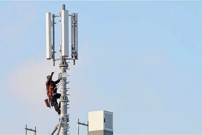 Ein Monteur arbeitet auf einem Mobilfunkmast. 