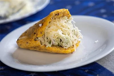 Arepa, ein Maisbrot, hier mit Reina Pepiaola (Hühnerfleischsalat mit Avocado, Gewürzen und geriebenem Käse) wird in Venezuela zu jeder Tageszeit verspeist. Gern auch zum Frühstück.