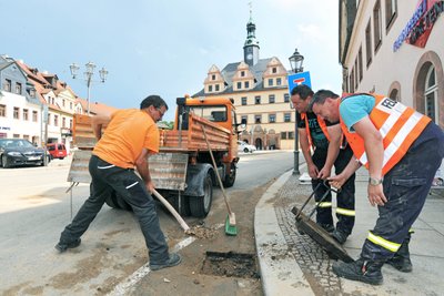 Peter Vasold, Mitarbeiter beim Peniger Bauhof, und die Feuerwehrleute Kevin Kirsch und Udo Lange (v.l.) haben am Mittwochnachmittag verstopfte Gullys gereinigt, damit Regenwasser wieder abfließen kann.