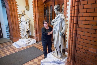 Kirchnerin Kathrin Schulze steht bei Paulus, im Hintergrund ist Petrus. Die beiden Figuren stehen seit November 2020 im Innenraum der St.-Nicolai-Kirche Aue. Sie wurden gesichert, weil es an ihrer Standfestigkeit mangelte. Wie es mit ihnen weitergeht, ist offen. 