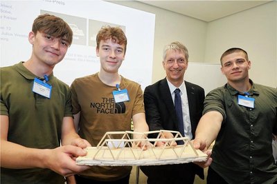 Die Freiberger Lino Sobe, Nils Orivol (v.l.) und Jonny Kaiser (r.) bekommen von Prof. Horst Biermann den Preis für die beste Leichtbaubrücke.