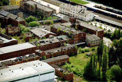 Eine aktuelle Aufnahme aus der Luft zeigt, wie marode der Ziegelkomplex gegenüber des Bahnhofs in Oelsnitz inzwischen ist. Die Dächer von mehreren Hallen sind bereits eingebrochen.  