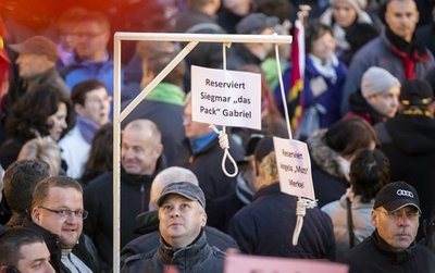 Das Corpus Delicti und sein Erbauer: Jens D. (mit Brille) hat eingeräumt, den für Angela Merkel und Sigmar Gabriel reservierten Galgen gezimmert und zur Demonstration präsentiert zu haben.