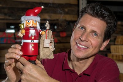 Firmenchef Ringo Müller mit einem Rauchknacker in Gestalt eines Weihnachtsmannes. Es handelt sich um eine Mischung aus Räuchermann und Nussknacker.