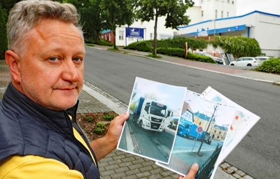 Bodo Steinhauser mit Aufnahmen, die er von den Lieferfahrzeugen gemacht hat. Hinter ihm ist der Rest eines Baumes zu sehen, der von einem Laster umgefahren wurde. 