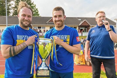 Der Vorsitzende Holger Tottewitz hatte eine Aufstiegstrophäe besorgt, die er Keeper Toni Grabowski (links) und Kapitän Pierre Bauer überreichte.