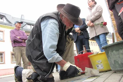 Der deutsche Künstler und Bildhauer Gunter Demnig verlegt an der Leipziger Straße den 126.001 Stolperstein.