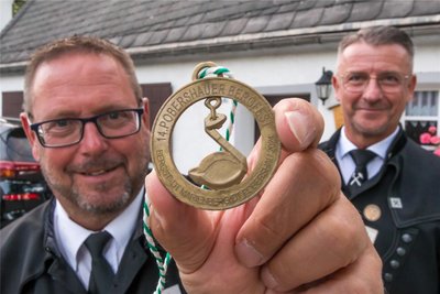 Ray Lätzsch, Vorsitzender des Sächsischen Landesverbandes der Bergmanns-, Hütten- und Knappenvereine sowie André Heinrich (v. l.), Oberbürgermeister der Stadt Marienberg, zeigen die Festplakette, die ab sofort erhältlich ist.