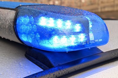Ein Streifenwagen der Polizei steht mit eingeschaltetem Blaulicht an einem Einsatzort.