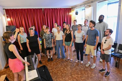 Einsingen im Chor „D′accord“. Lisa-Anna von Ell steht am E-Piano, alle anderen machen sich locker.