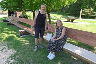 29,75 Meter lang: Neue XXL-Bank steht jetzt auf dem Aschberg - Eine Bank als Attraktion unterhalb der Jugendherberge: Hausmeister Ralph Koschemann beim Farbanstrich und Herbergsleiterin Jana Ebers beim Probesitzen.