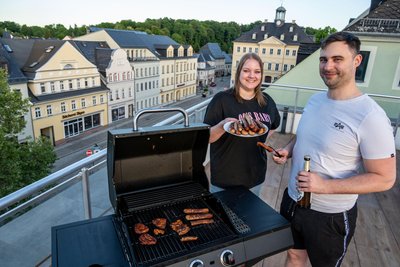Darline Flieher (l.) und Philipp Baumung können von der Dachterrasse ihres „ProZone Gaming Apartments“ auf den Hainichener Markt blicken.