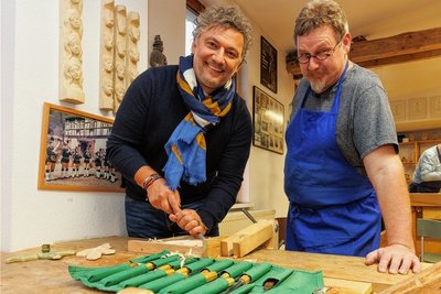 Jonas Kaufmann versuchte sich selbst im Schnitzen. Der Leiter der Annaberger Schnitzschule, Volker Krämer (rechts), bescheinigte dem Star-Tenor durchaus geschickte Hände. Foto: Ronny Küttner