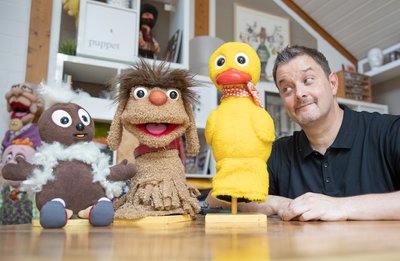 Der Figurenschneider Norman Schneider neben den Sandmännchen-Puppenfiguren "Pittiplatsch" (l-r), "Moppi" und "Schnatterinchen". 