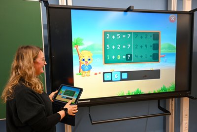 Vom Lehrer-Tablet an die elektronische Tafel: Schulleiterin Silvia Thiel-Meyer mit Rechen-Aufgaben für Erstklässler.