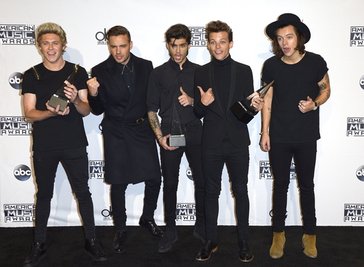 Die Musikgruppe One Direction posiert mit ihren drei Awards auf dem roten Teppich.