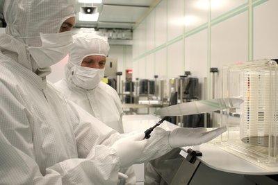 Nils Seifert (l.), Azubi bei Siltronic in Freiberg, kontrolliert mit Ausbilder und Teammanager Dr. Jörg Haberecht die Qualität eines Siliziumwafers.
