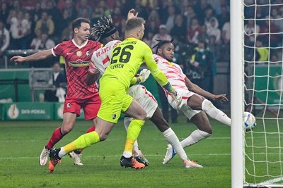 Freiburgs Torwart Mark Flekken (26) kann den Schuß von Leipzigs Christopher Nkunku (r) nicht halten und kassiert das 1:1.