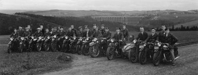 Mitglieder des Motorradklubs Triumph Mylau und Umgebung am 7. Mai 1933 vor einer Ausfahrt ins Waldhotel "Zöbischhaus" in Bad Reiboldsgrün. Die Aufnahme mit Blick auf die Göltzschtalbrücke entstand in Reinsdorf nahe des längst abgerissenen Klublokals "Zur schönen Aussicht". 