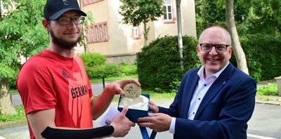 Eine Medaille mit Kulturhauptstadt-Logo als Glücksbringer: Oliver Hörauf (links) wird von OB Sven Schulze verabschiedet. 