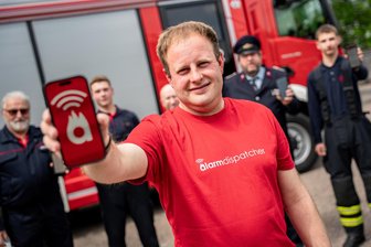 30.000 Alarmierungen am Tag: Feuerwehr-App aus Freiberg spart wertvolle Sekunden - Willi Schmidt, gebürtig in Freiberg, hat 2016 die Alarm Dispatcher App auf den Markt gebracht. Im Hintergrund die Kameraden der Freiwilligen Feuerwehr Zug.