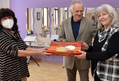 Bettina und Peter Bretschneider freuen sich über den Dankeschön-Stollen der Weihnachtsaktion der "Freien Presse". Gabi Fritsch (links) übergibt die leckere Süßigkeit aus dem Erzgebirge. 