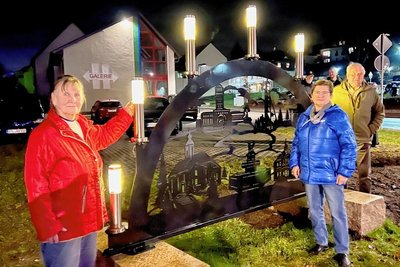 Helga Gleditzsch, Roswitha Bartschat und Lothar Bartschat (v.li.) am neuen Oelsnitzer  XXL-Schwibbogen vorm Hartmannhaus. 