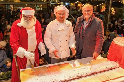 Auerbachs OB Jens Scharff hat am Freitagabend zusammen mit Bäckermeister Steve Brasch (Mitte) und dem Weihnachtsmann angeschnitten.