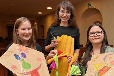 Stella Baumgarten (links) und Pia Matthes (rechts) haben mit Museumspädagogin Alexandra Weber einen Drachen gebastelt. 