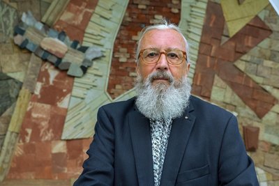 Konrad Felber vor einem mit von ihm beauftragten Mosaik in der Stadthalle Limbach-Oberfrohna. Das Kunstwerk vereint die Anfangsbuchstaben aller Stadtteile.