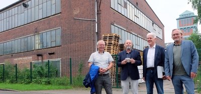 Bürgermeister Bernd Birkigt, Kurator Alexander Ochs, Galerist Wolfgang Häusler und Architekt Jens Zander (von links) am Gebäude 17. In dem einstigen Schachtgebäude hinter dem Bergbaumuseum soll ein Großkunstwerk des amerikanischen Künstlers James Turrell entstehen.