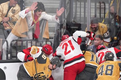 Ein Elvis-Imitator schlägt auf die Scheibe, während die Spieler um den Puck kämpfen.