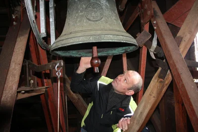 Jürgen Fritzsche vom Kirchenvorstand begutachtet die kleine Glocke der Lauterbacher Kirche.