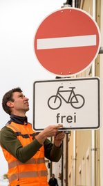 Bauhof-Mitarbeiter Dirk Schmeller montiert die neue Beschilderung, auf die auch Autofahrer besonders achten sollten.